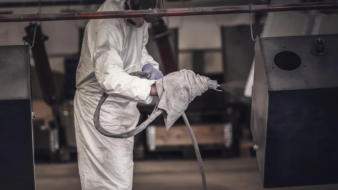 Mitarbeiter lackiert die Oberfläche eines Werkstücks